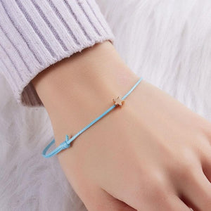 Make A Wish stackable, adjustable bracelet. Black adjustable string band with gold-tone star.